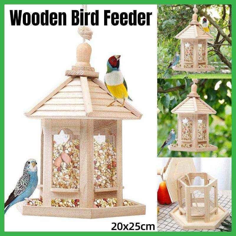 Hexagonal wooden bird feeder hanging in outdoor garden
